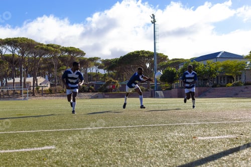 Preview: Three African American young male athletes training on a sunny field