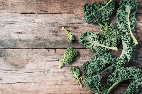 Preview: Fresh green curly kale on wooden background. Top view, copy space. Zero waste, organic vegetables