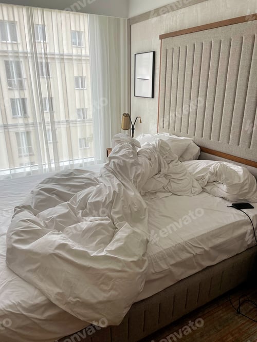 Untidy Bed in Modern Hotel Room Interior