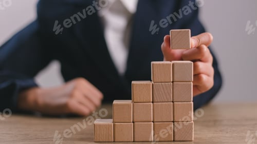 Preview: Businesswomen stack blank wooden cubes on the table with copy space, empty wooden cubes
