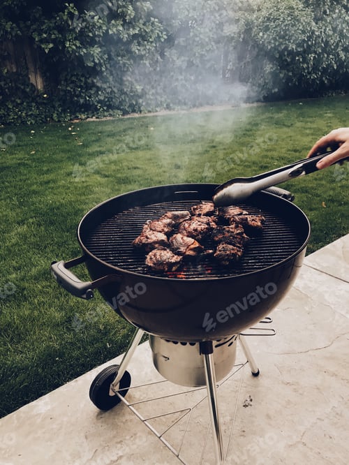 Preview: Backyard barbecuing some chicken thighs and flipping them with tongs