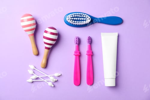 Preview: Flat lay composition with baby toothbrushes and toiletries on color background