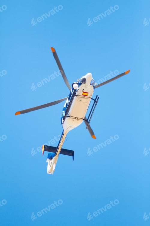Preview: Canvasing the area. Low angle shot of a police helicopter in the sky.