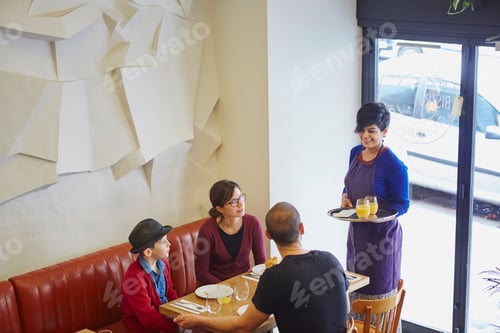Preview: Waitress serving lunch in restaurant to family with son