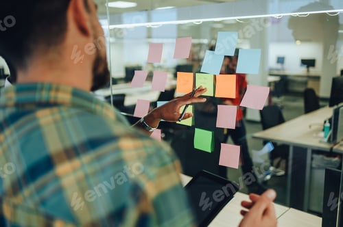 Preview: Close up of a creative team writing ideas and concepts on sticky notes.