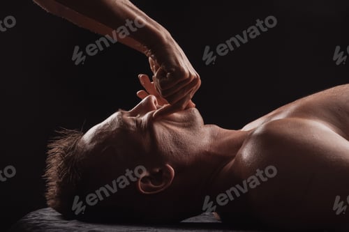 Preview: Therapist performs intraoral massage on a man's face for deep muscle release and therapy.