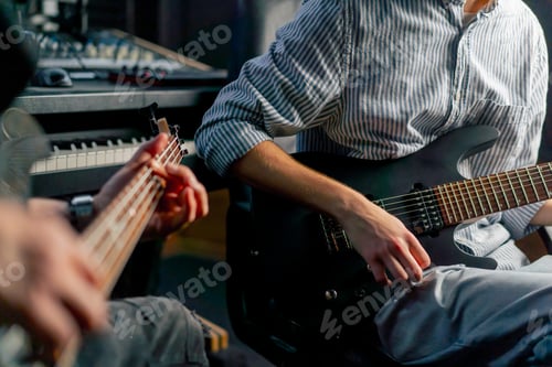 Preview: close up in the equipment of the recording room handsome man with a beard and tattoos and his young