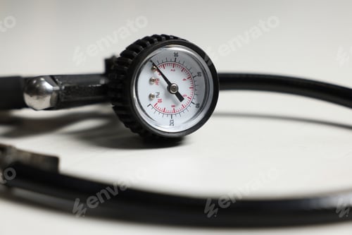 Preview: One tire inflation gun with gauge on light background, closeup