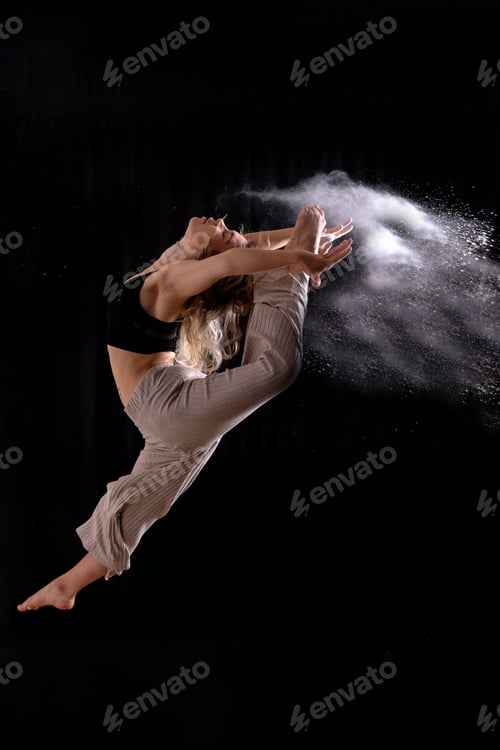 Preview: Young dancer performing a jump in studio photo session with a black background, ballet