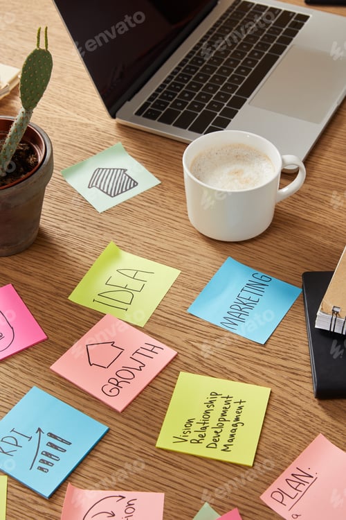 Preview: paper stickers with business strategy, cup of tasty coffee and laptop on tabletop