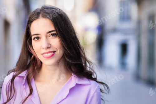 Preview: Young ethnic woman smiling on urban street