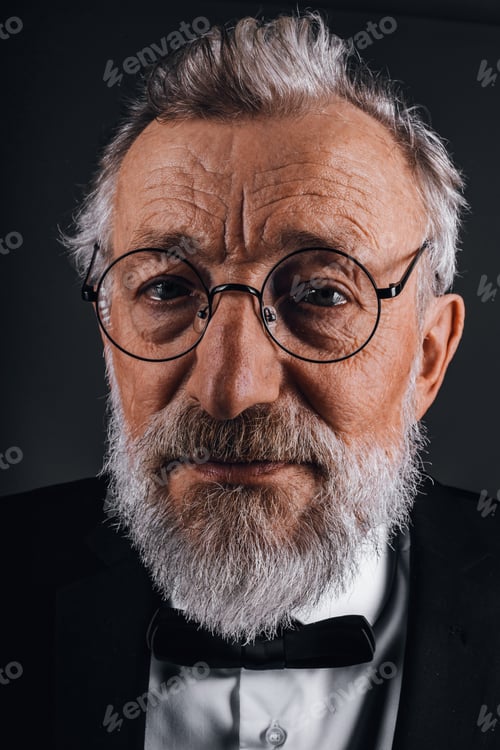 Preview: Closeup portrait of confident mature man in tuxedo isolated on black background