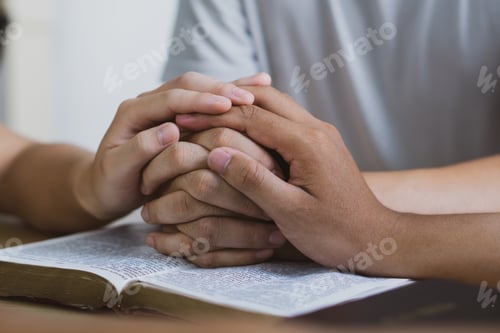 Preview: ing Prayer meeting concept.Colleagues shaking hands reading scriptures and praying to God.