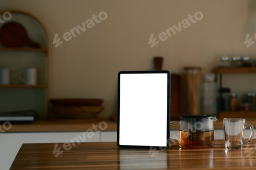 Preview: Digital tablet standing on a wooden countertop next to a glass teapot and cup