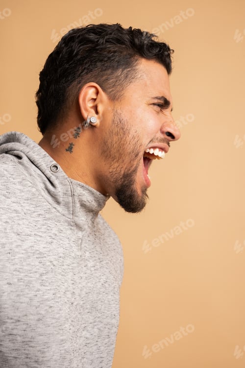 Preview: Colombian man shouting with open mouth in studio shot