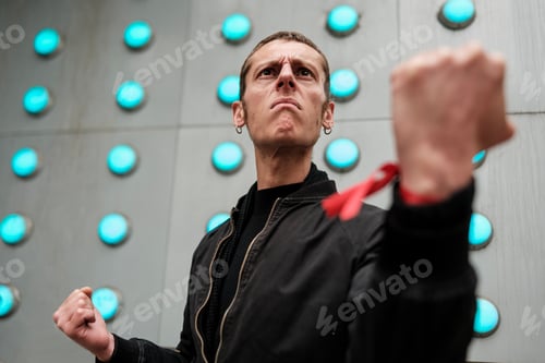 Preview: Activist showing fists and red ribbon on wrist during protest