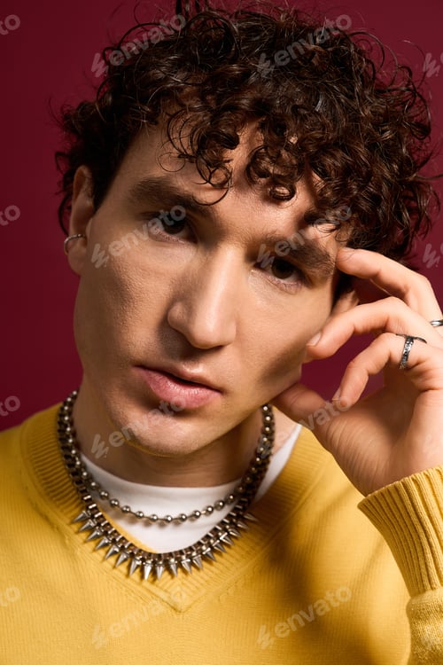 Preview: Stylishly handsome man showcases unique fashion against a vibrant background