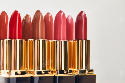 Preview: selective focus of various red shades of lipsticks isolated on grey