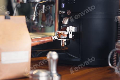 Preview: Coffee portafilter engaged bean grinder, close up detail view copy space includes.