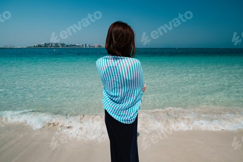 Preview: Back view of woman walking the sea in Dubai