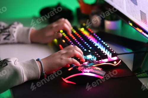 Preview: Gamer. A teenager is playing on the computer in the evening time. Keyboard computer,using technology