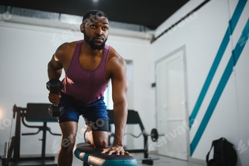 Preview: Weight training African doing bodybuilding in gym.