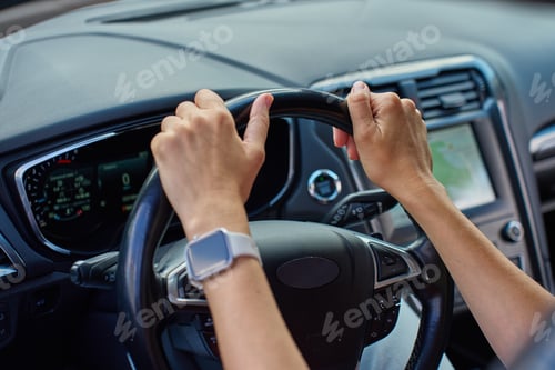 Preview: Driver hands holding steering wheel inside modern car close-up