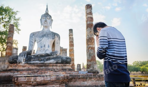 Vista previa: young thai male tourist praying at sukhothai historial park thailand
