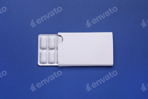 Preview: Blister with chewing gums on blue background, top view