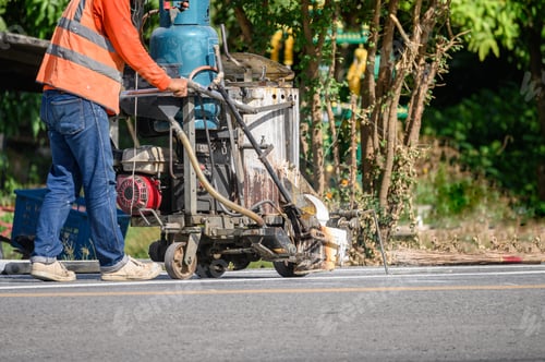 Preview: Worker wearing uniform is making the white line on road with painting machine
