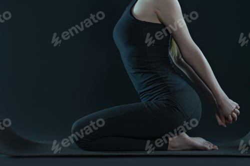 Preview: Young woman practicing yoga positions . sport workout fitness exercise. yoga mat black background.
