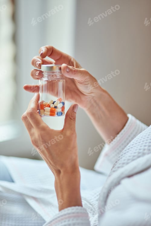 Preview: Beautiful female hands holding bottle with vitamins