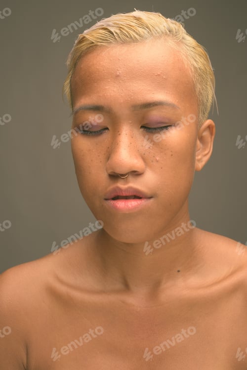 Preview: Young beautiful rebellious woman with short hair against gray background
