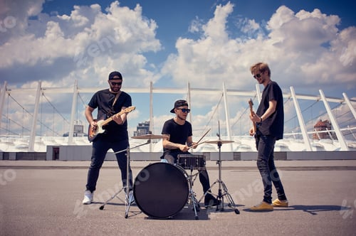 Preview: rock band in black clothing playing music on street