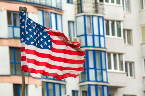 Preview: Close up of the us flag against city skyline