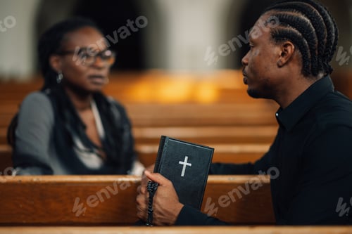 Preview: Priest holding holy bible listening to woman in church