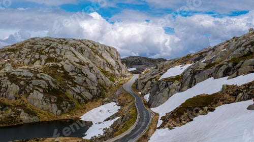 Preview: A scenic road twists through a breathtaking Norwegian mountain pass, with snow-capped peaks and a