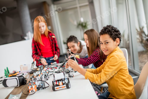 Preview: Happy kids programming electric toys and robots at robotics classroom
