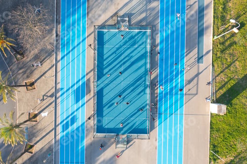 Preview: Aerial view of blue artificial football and basketball field.
