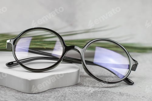 Preview: Stylish round glasses for vision on a beige podium, close-up