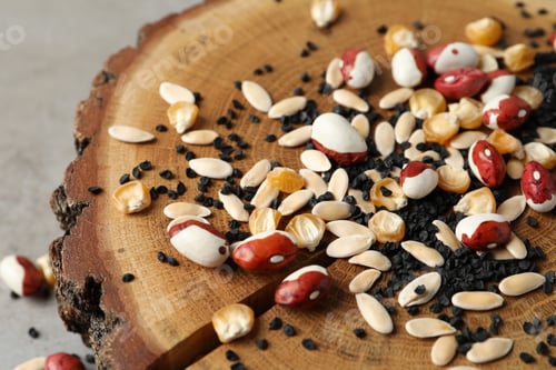 Preview: Mixed vegetable seeds on wooden log, closeup