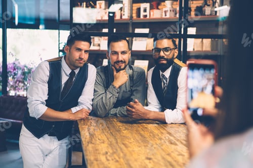 Preview: Woman taking photo of three handsome men