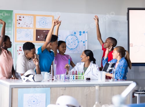 Preview: In school, students raising hands and engaging with Indian female teacher in science classroom