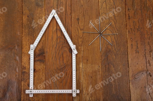 Preview: Top view of a house made from a measuring tape and sun with nails
