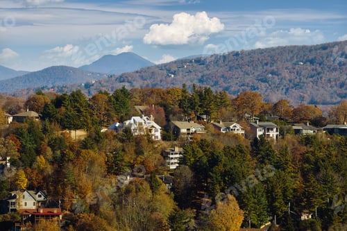 Preview: View from above of expensive residential houses high on hill top between yellow fall trees
