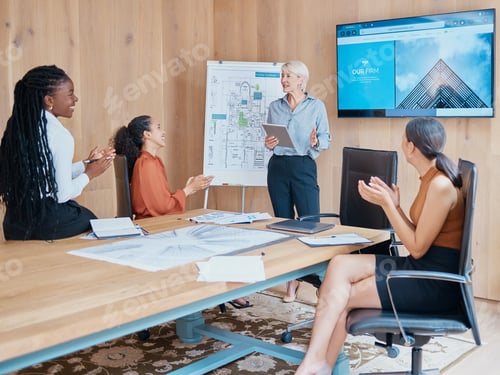 Preview: Mature caucasian businesswoman smiling and standing using a tablet while giving a presentation in t