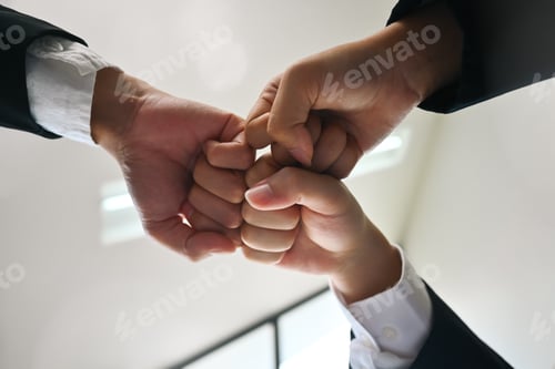 Preview: Businesspeople giving fist bump at meeting. Concept of corporate unity, motivating.