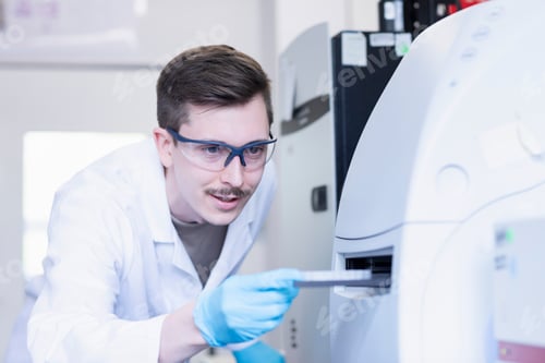 Preview: Focused scientist operating advanced laboratory equipment.