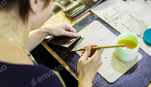 Preview: woman smearing with glue a part of a wallet
