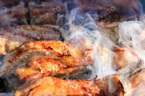 Preview: Barbecue skewers with juicy meat cooking in open air in summer. Food background.